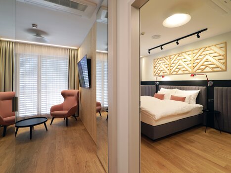 Insight into a hotel room featuring a seating area and bed. | © Hotel Steiermarkhof