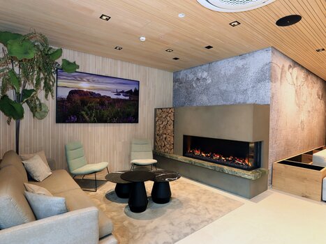 Bright lounge with sofa, plants, and modern fireplace. | © Hotel Steiermarkhof