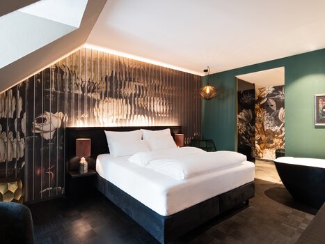 Elegant bedroom with floral design and stylish furnishings. | © Aiola Living