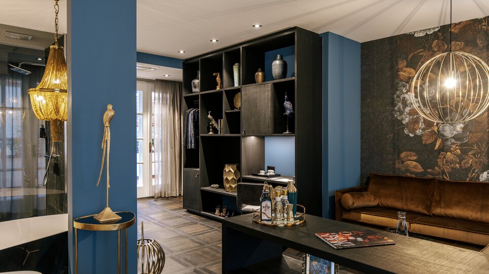 Stylischer Wohnbereich mit blauen Wänden und moderne Möbel im Aiola Living. | © Aiola Living