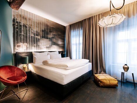 Stylish room with bed, ambient lighting, and artwork. | © Aiola Living