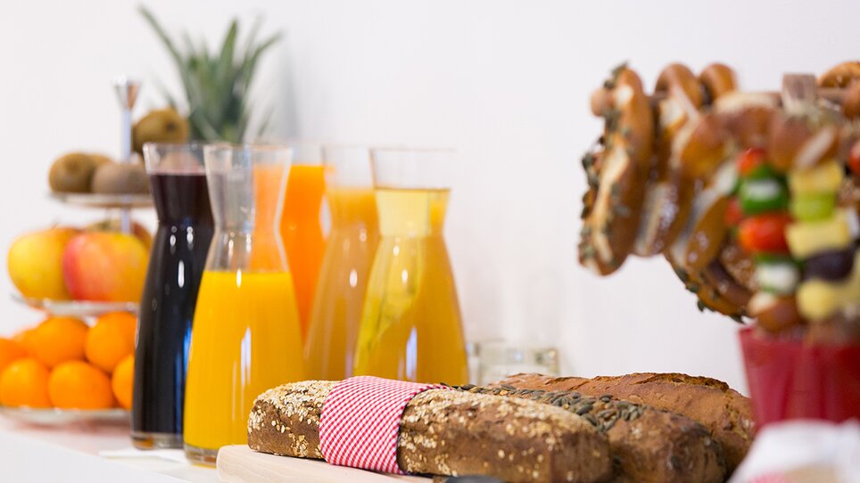 Varietà di succhi, pane e frutta per colazione. | © sHome Hotel
