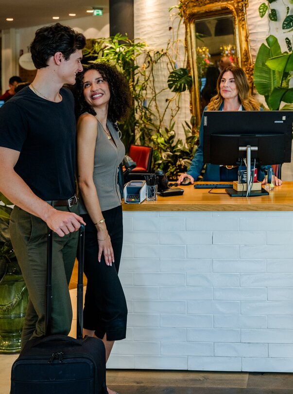 Check-in at the Hotel Weitzer in Graz | © Graz Tourismus - Mias Photoart A couple is standing in front of reception at the Hotel Weitzer with a suitcase, checking in. | © Graz Tourismus - Mias Photoart