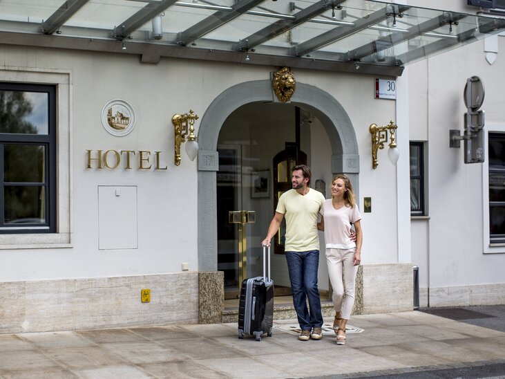 Couple with suitcase in front of the Schlossberghotel in Graz | © Graz Tourismus - Tom Lamm