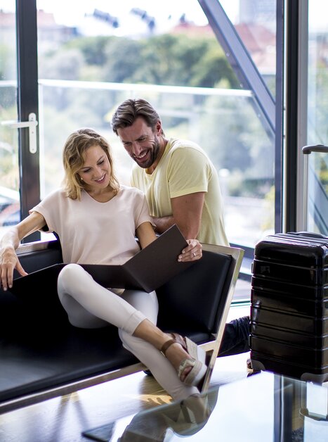 Couple with suitcase sitting in the lobby of the Schlossberghotel in Graz | © Graz Tourismus - Tom Lamm