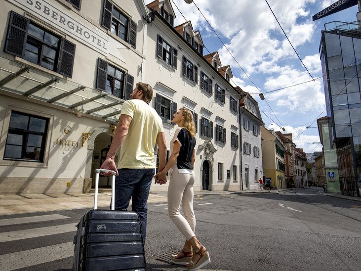 Pärchen mit Koffer vor dem Schlossberghotel in Graz | © Graz Tourismus - Tom Lamm